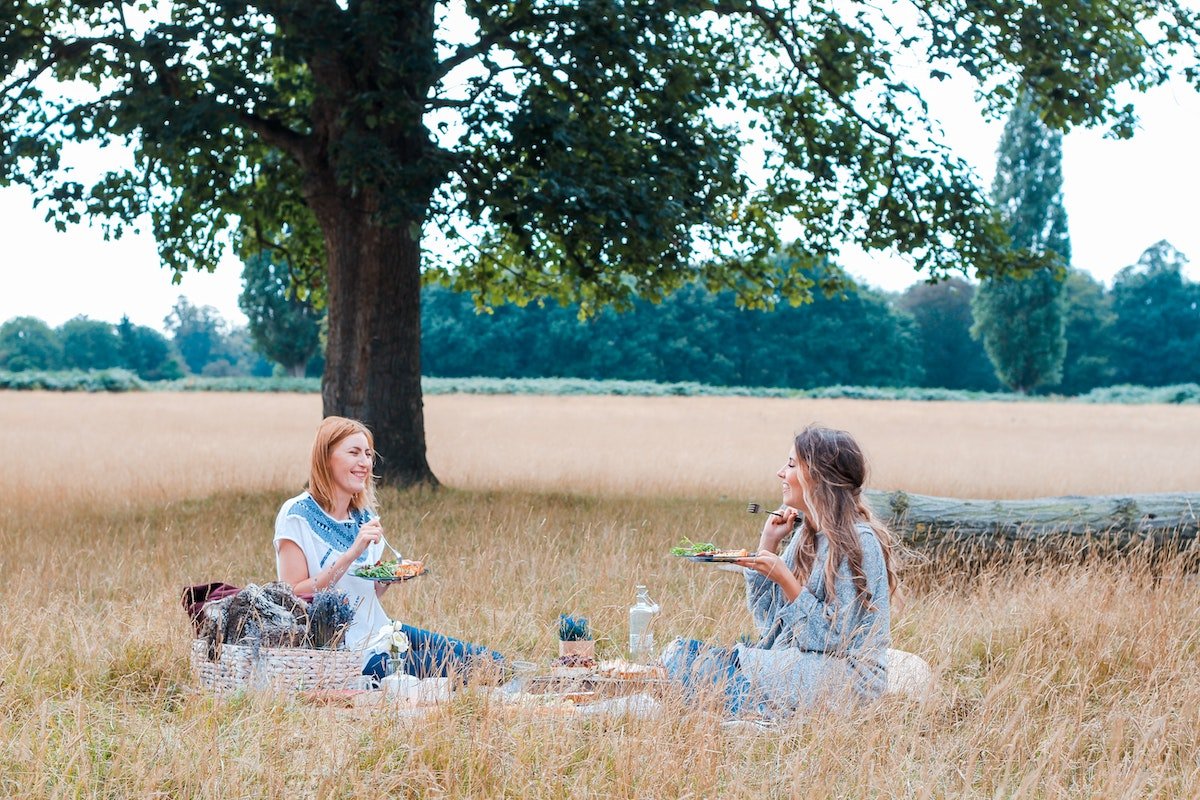 fall picnic two women eating in field
